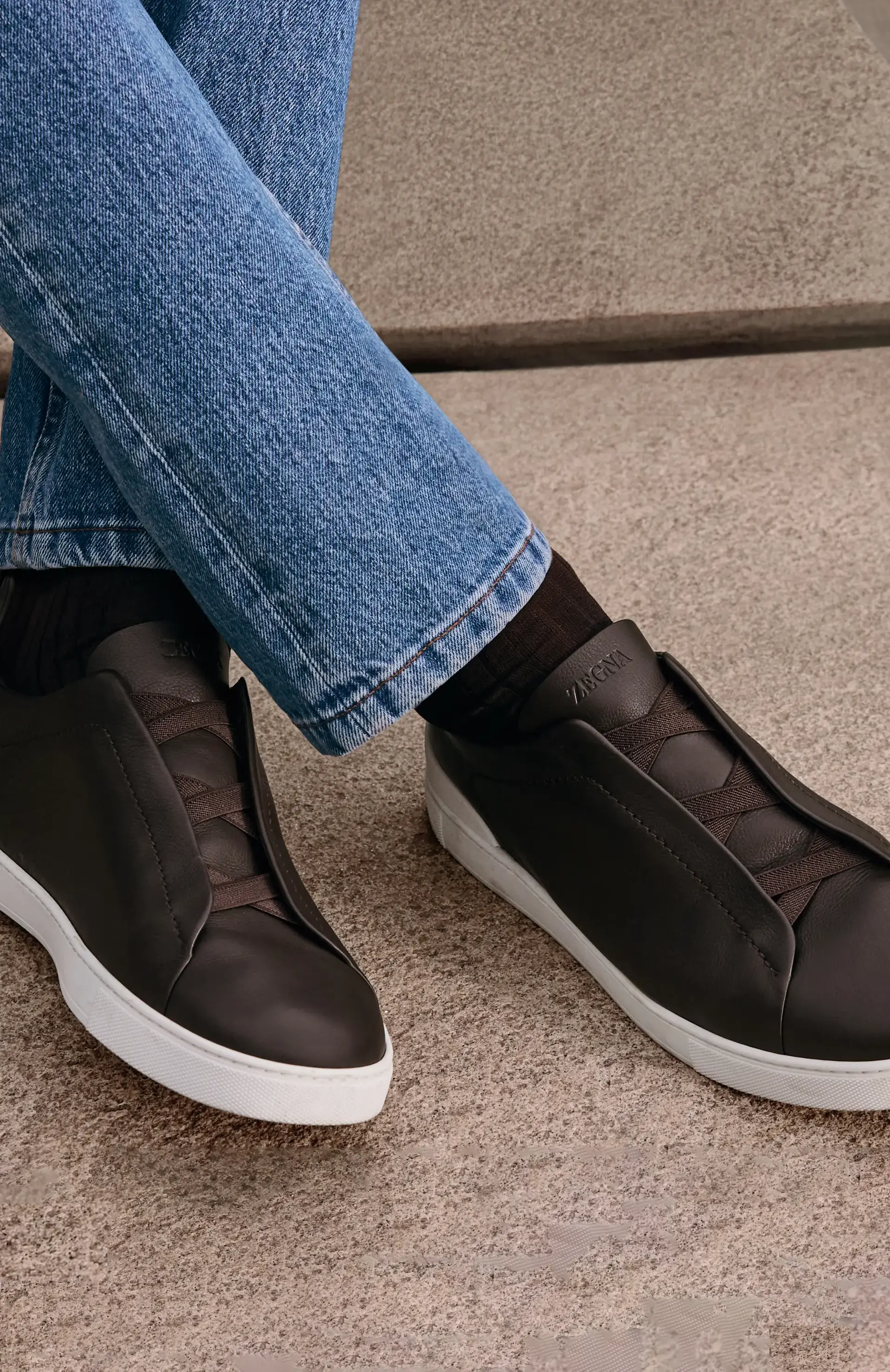 Un hombre vestido con los sneakers de lujo Triple Stitch™ con denim, de la colección Otoño-Invierno 2025 de ZEGNA.