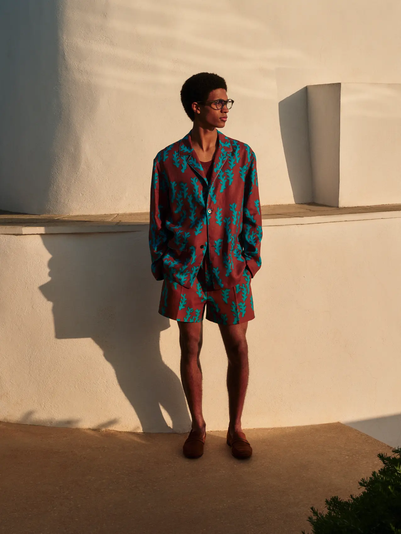 Image 2: Man wearing a bold printed summer set featuring a relaxed-fit buttoned shirt and matching shorts by ZEGNA.
