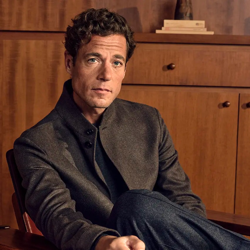 Homme assis portant la veste Beaver Il Conte en Oasi Cashmere mélangé vert olive foncé, un pull à col rond Cashseta et un pantalon en laine, soie et cachemire gris foncé, issus de la collection Automne/Hiver 2026 de ZEGNA.