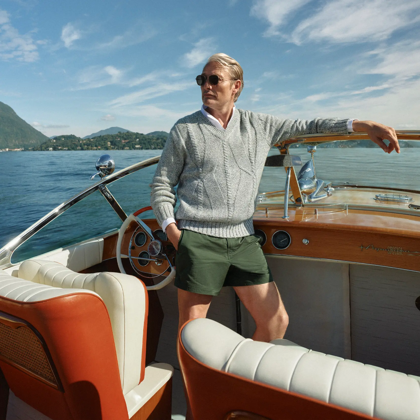 Mads Mikkelsen on a boat wearing a ZEGNA Spring Summer 2026 look featuring a V-neck sweater and the iconic Rio beachwear