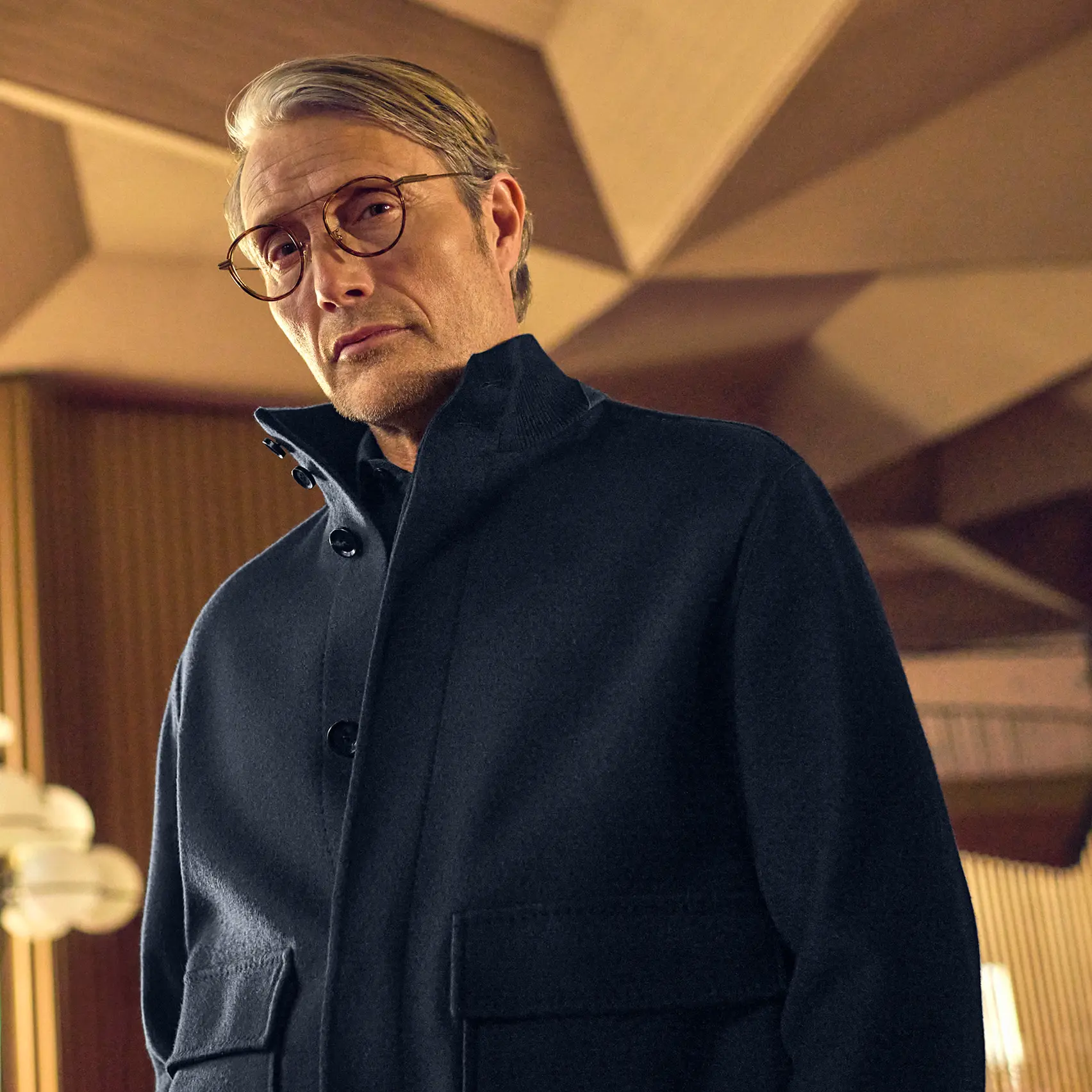 Mads Mikkelsen portant un look décontracté, raffiné et monochrome, photographié au Teatro Regio pour la collection FW25 de ZEGNA.