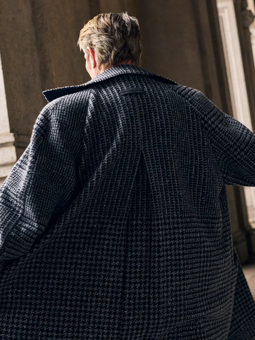 Mads Mikkelsen wearing a coordinated houndstooth coat and suit in Torino style, from the ZEGNA FW25 collection.