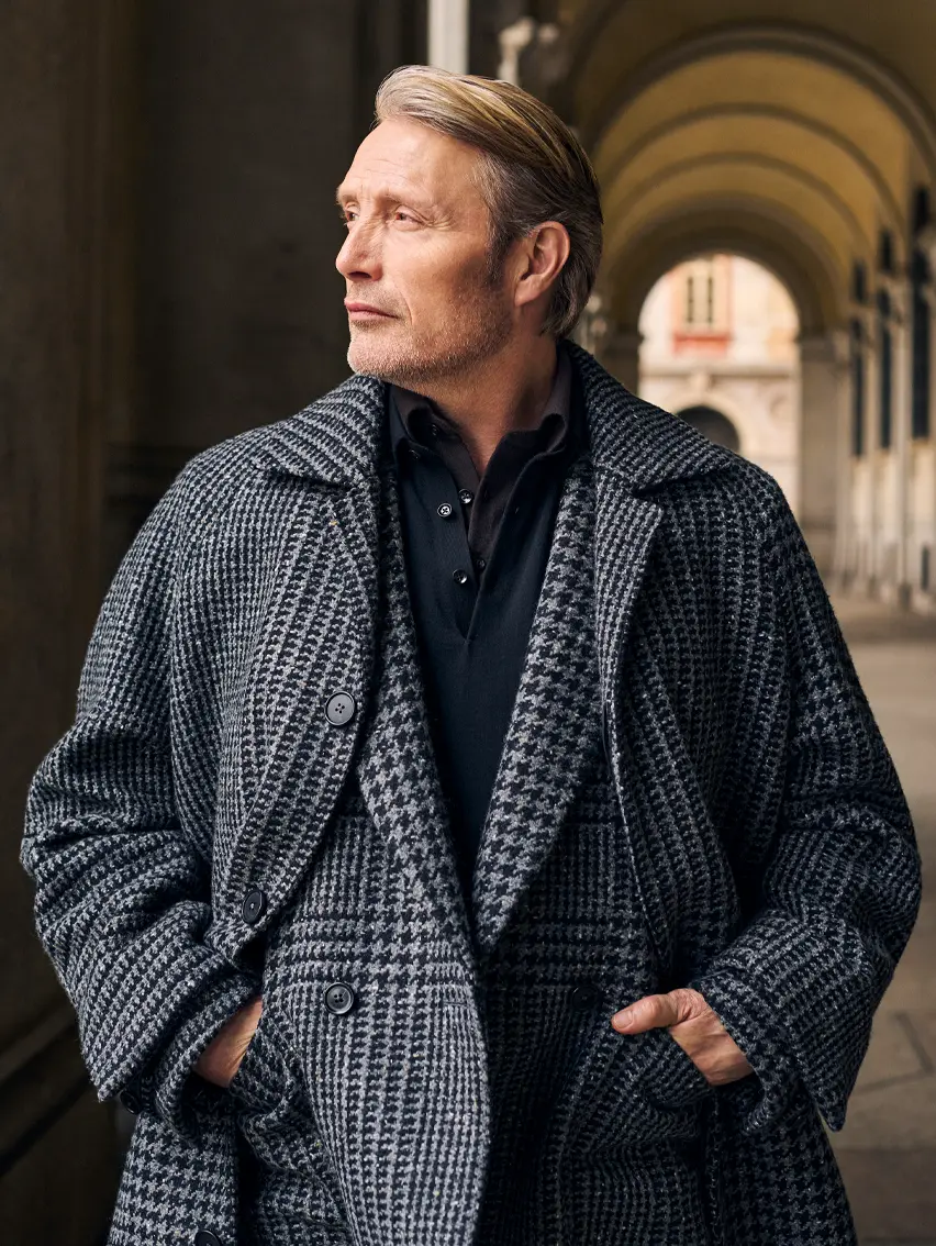 Mads Mikkelsen wearing a coordinated houndstooth coat and suit in Torino style, from the ZEGNA FW25 collection.