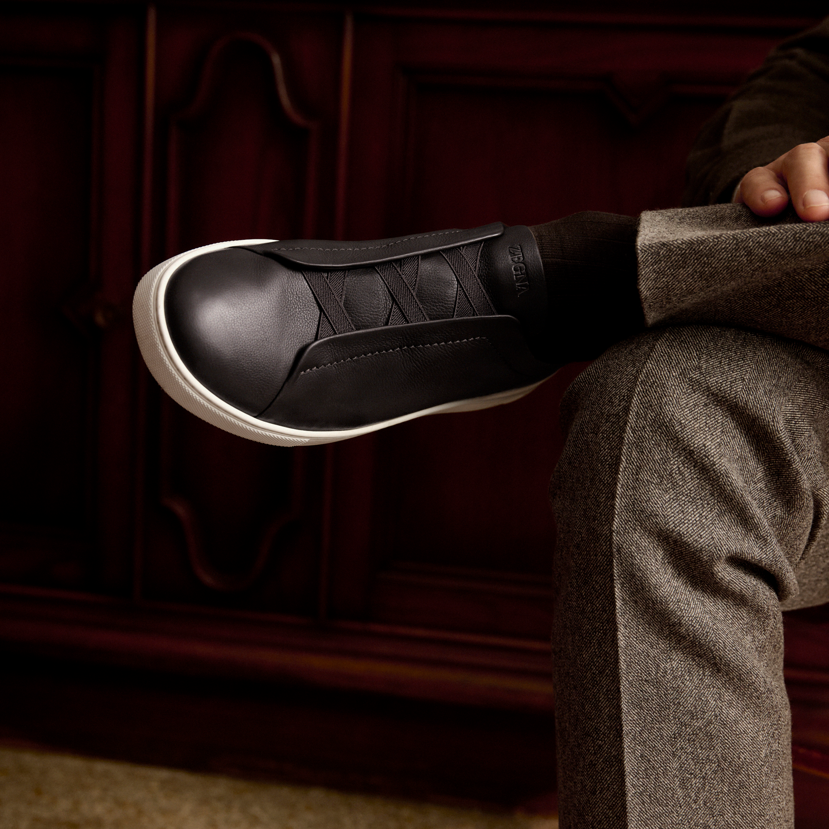 Close-up of a man wearing a black leather Triple Stitch sneaker,  from the ZEGNA Fall/Winter 2026 collection.