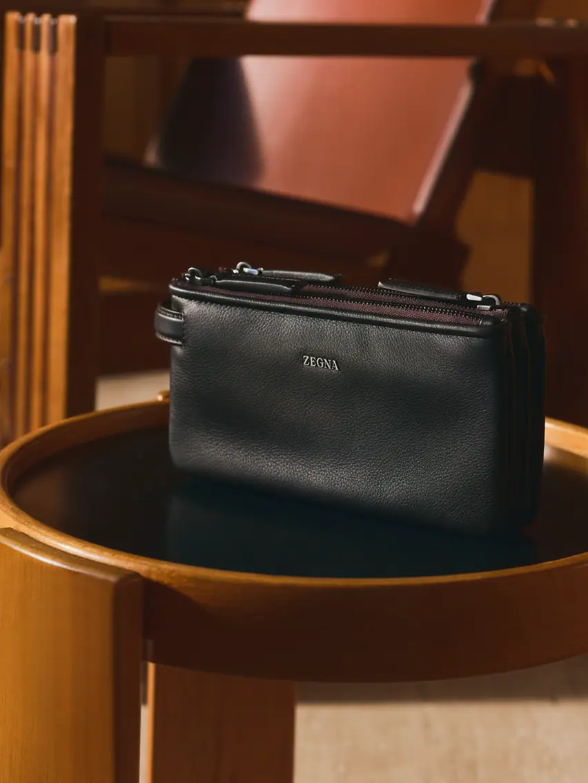 ZEGNA Secondskin-Pouch, präsentiert inmitten eines edlen Stilllebens.