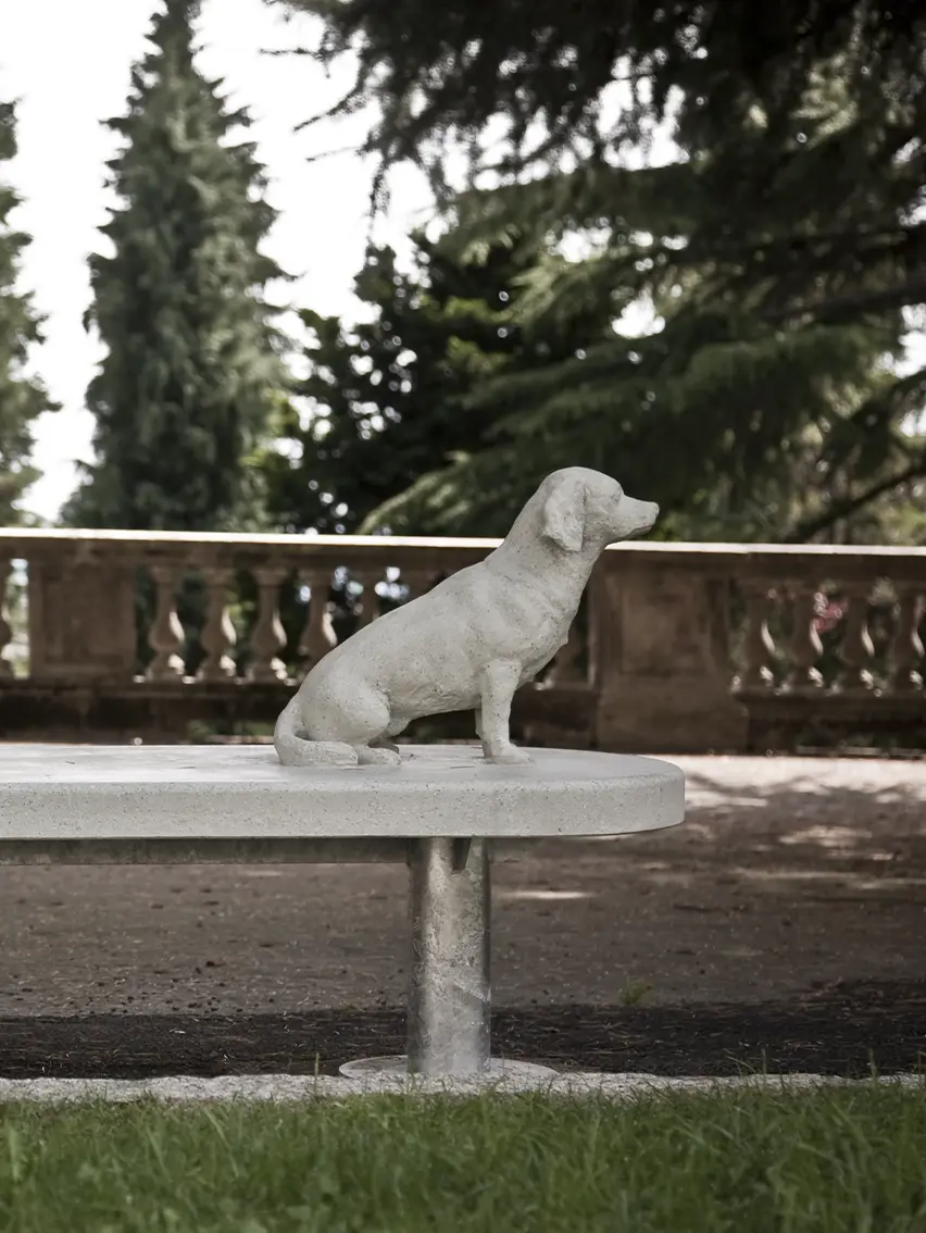 A public bench with a sculpture of a dog seated on it, part of Alberto Garutti's installation.