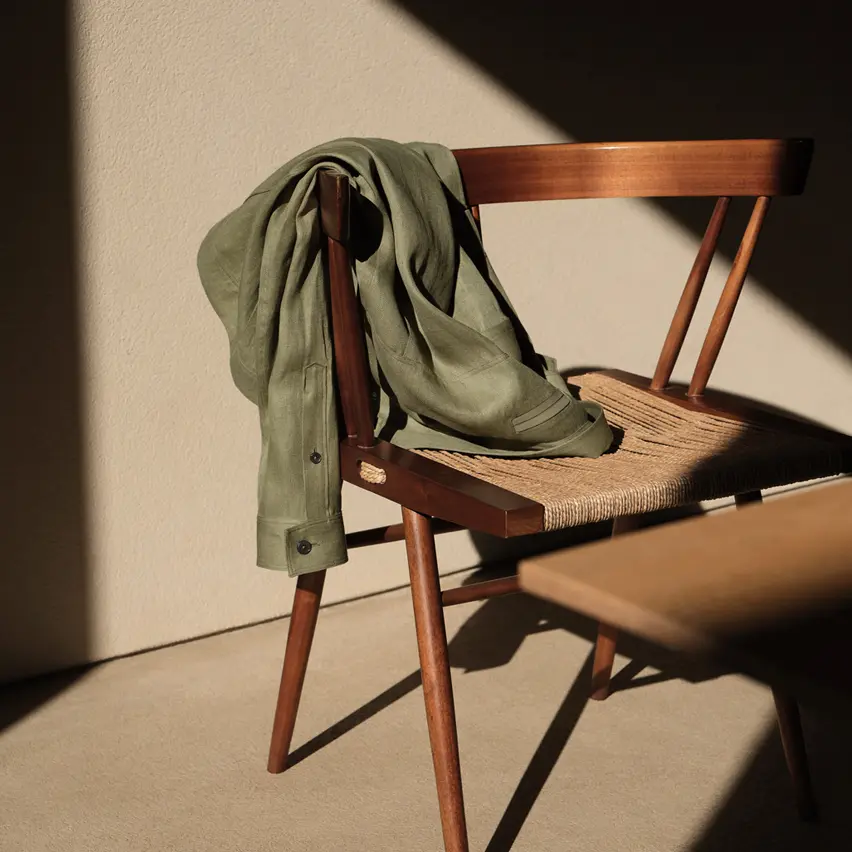 Ein olivgrünes Jackett von ZEGNA liegt auf einem Holzstuhl.