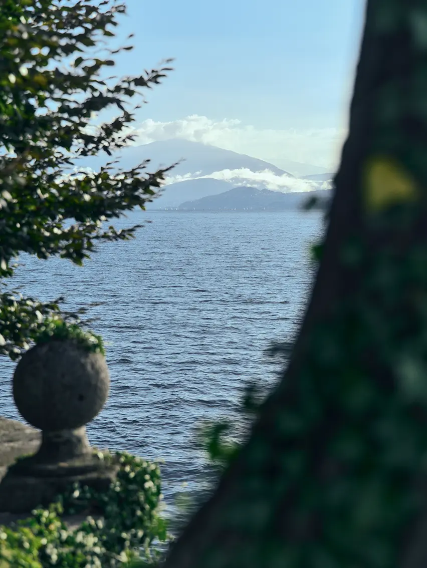 Statue overlooking Lake Maggiore with mountains in the background.