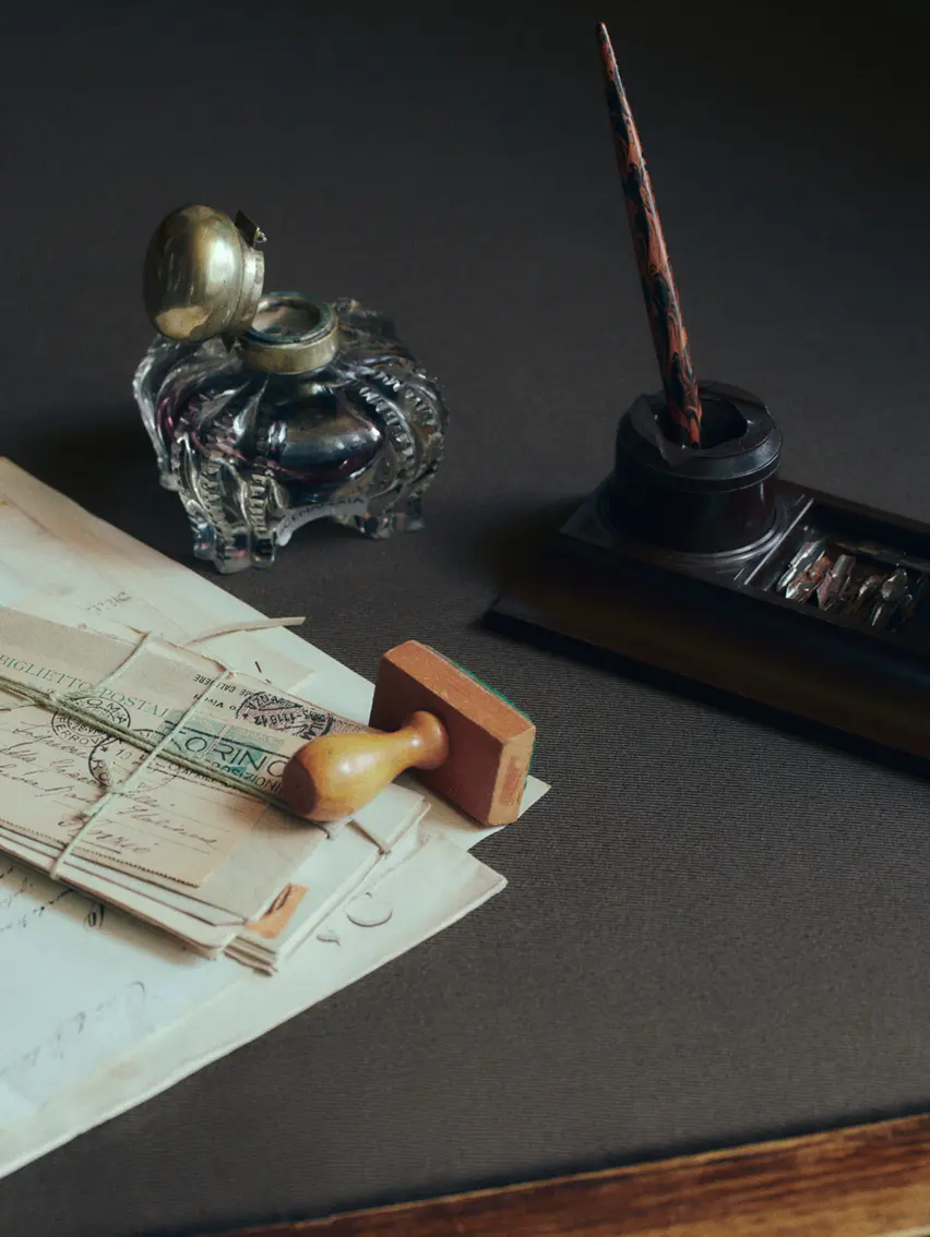 Elegant writing desk arranged with letters and a prominent inkwell.