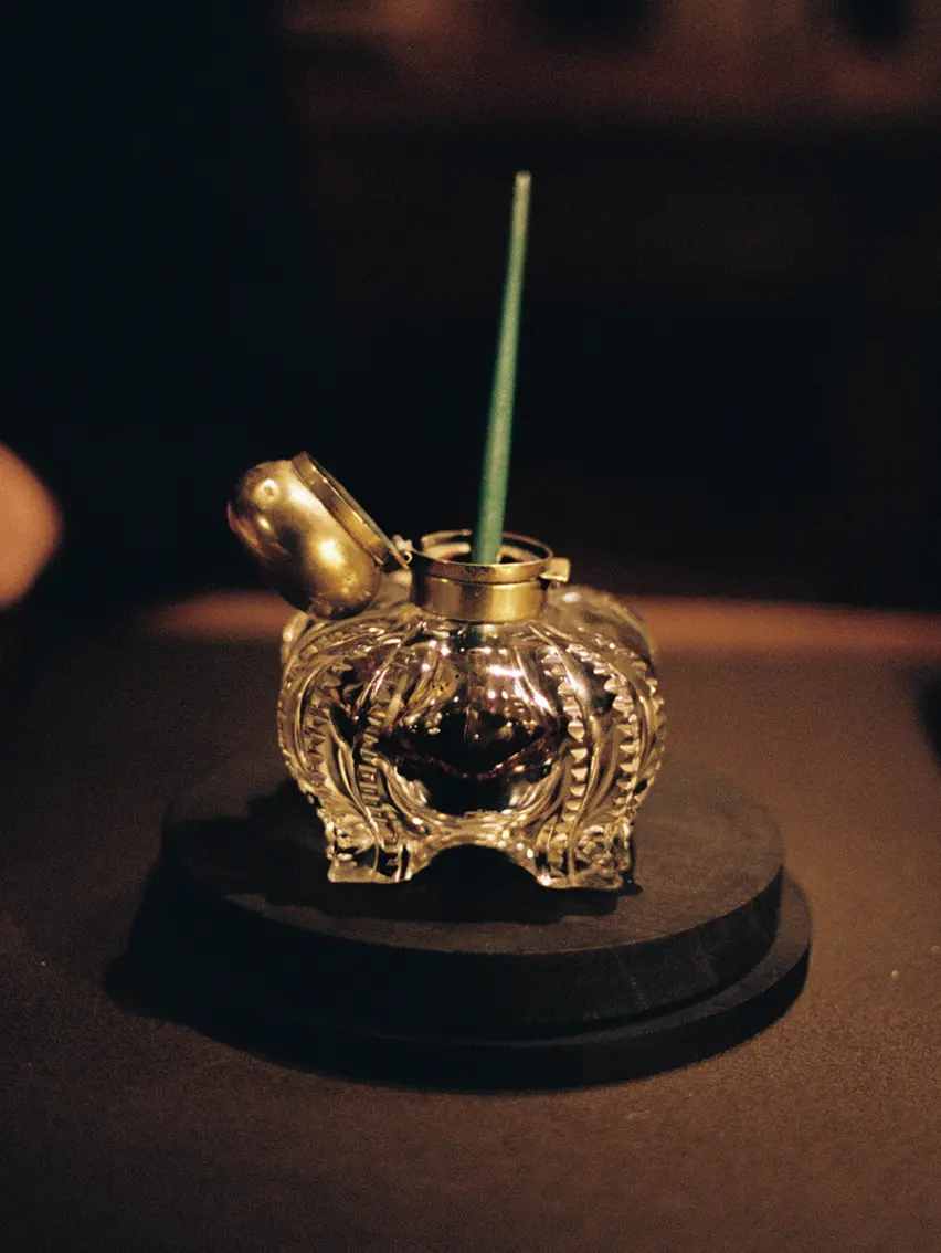Close-up of a writing desk detail featuring an inkwell, evoking reflection.