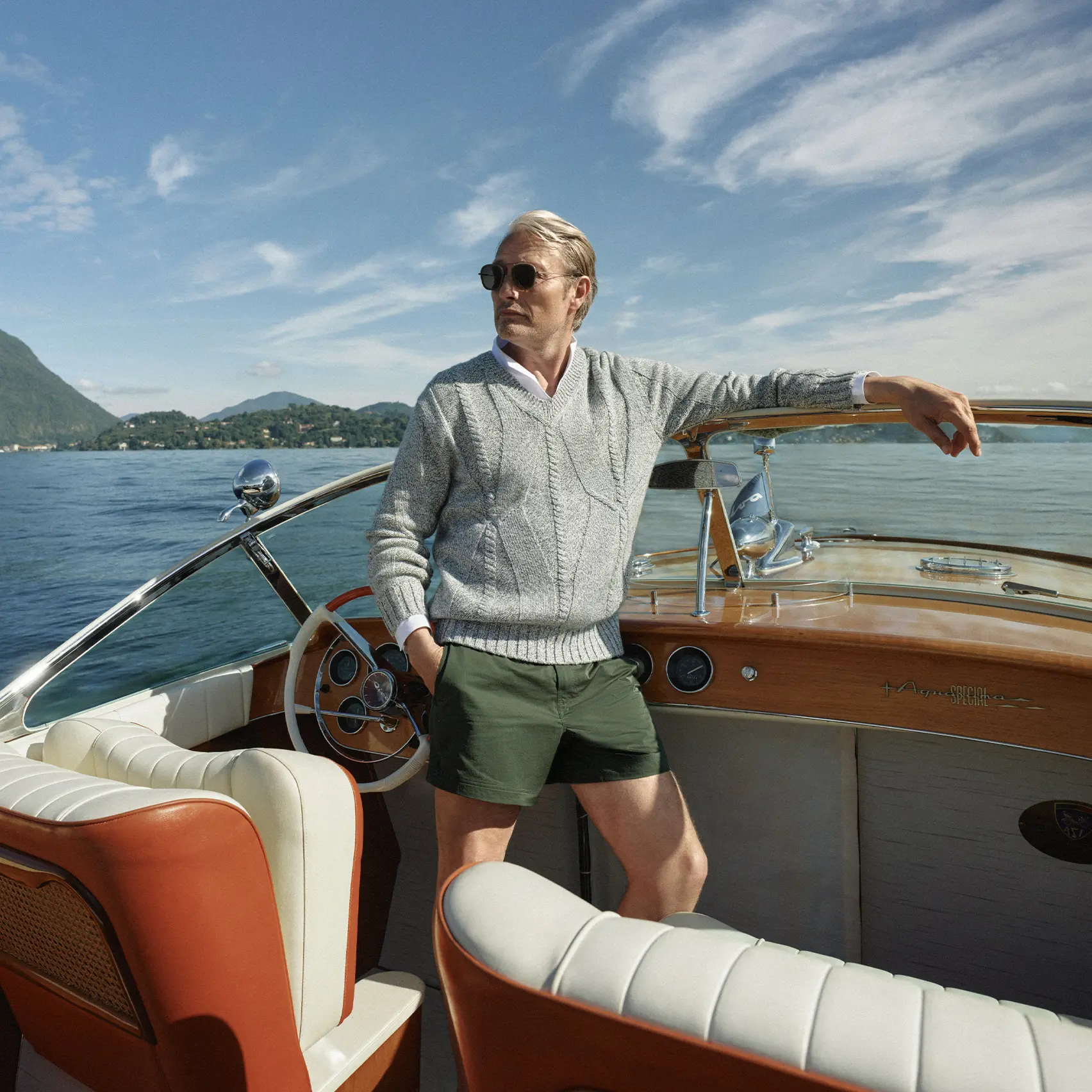 Mads Mikkelsen on a boat wearing a ZEGNA Spring Summer 2026 look featuring a V-neck sweater and the iconic Rio beachwear.