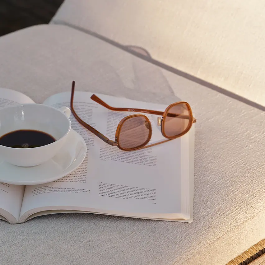 Foliage Orizzonte II acetate and metal sunglasses with round lenses by ZEGNA, resting on a sunbed.