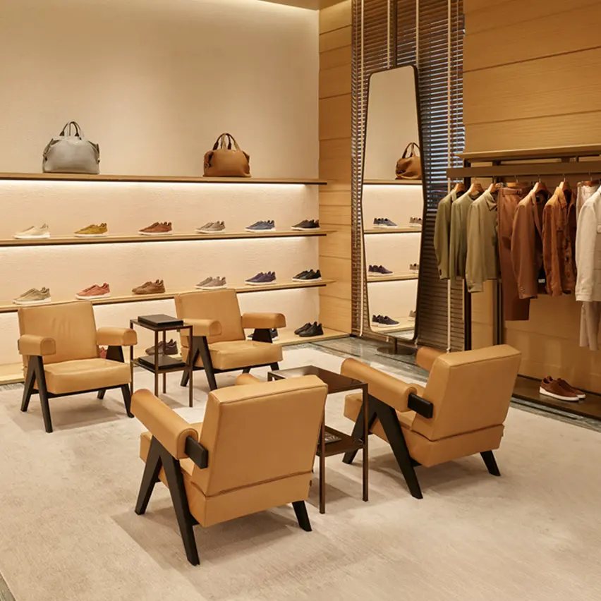 Innenansicht eines ZEGNA Luxus-Stores mit Schuhen, Taschen und Kleidung, die elegant in Regalen ausgestellt sind.