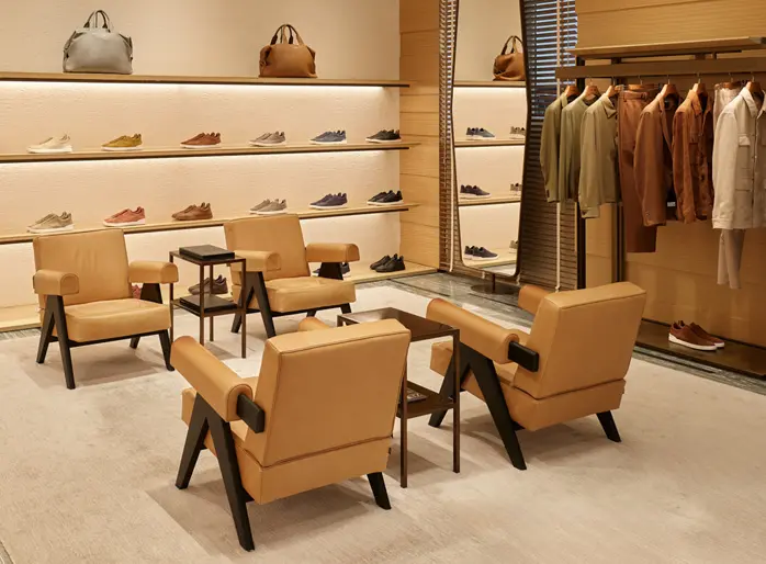 Interior of ZEGNA luxury boutique with shoes, bags, and clothing elegantly displayed on shelves.