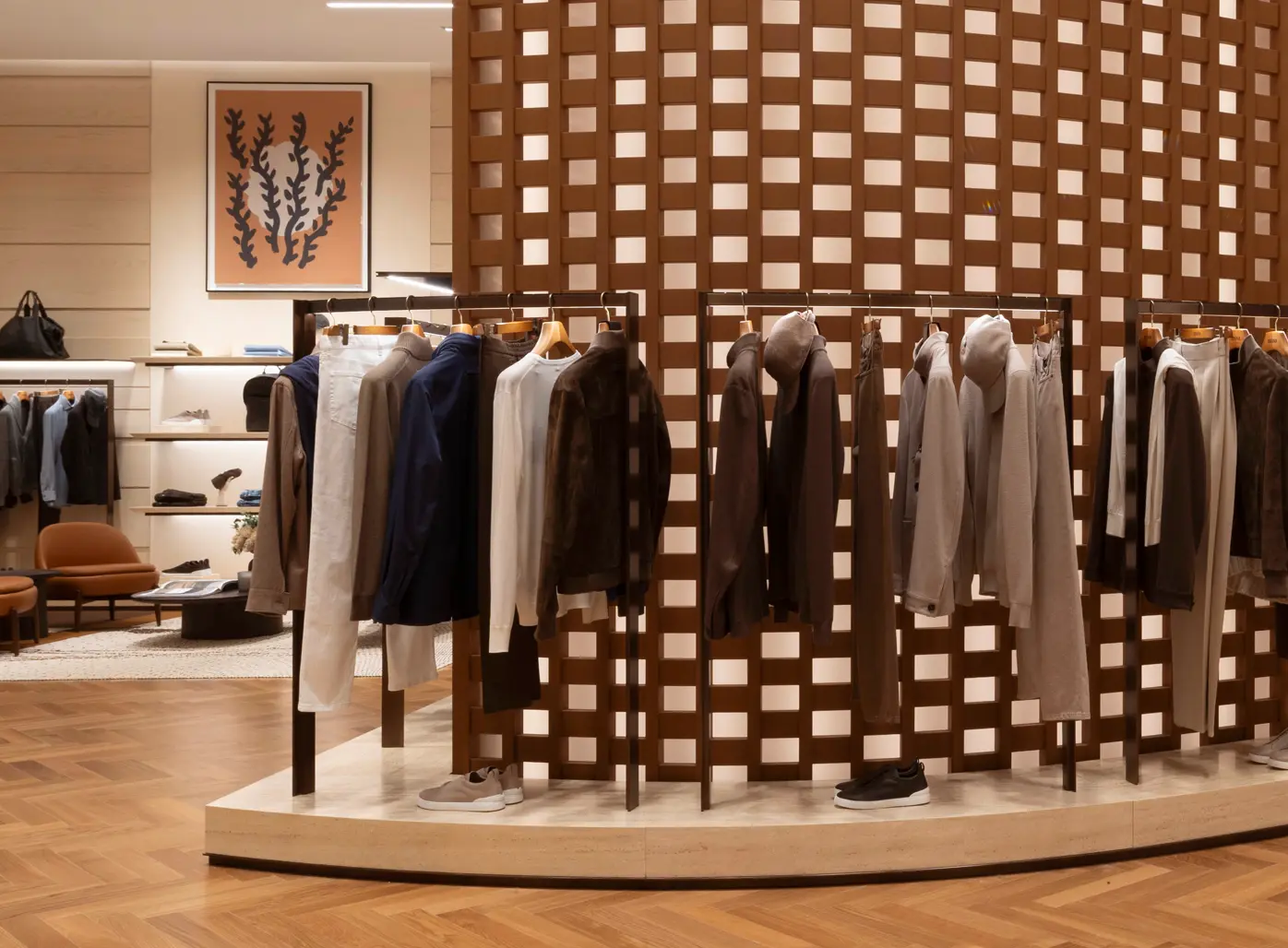 Innenansicht der ZEGNA-Luxusboutique mit elegant auf Regalen und Kleiderstangen präsentierten Schuhen und Kleidungsstücken.