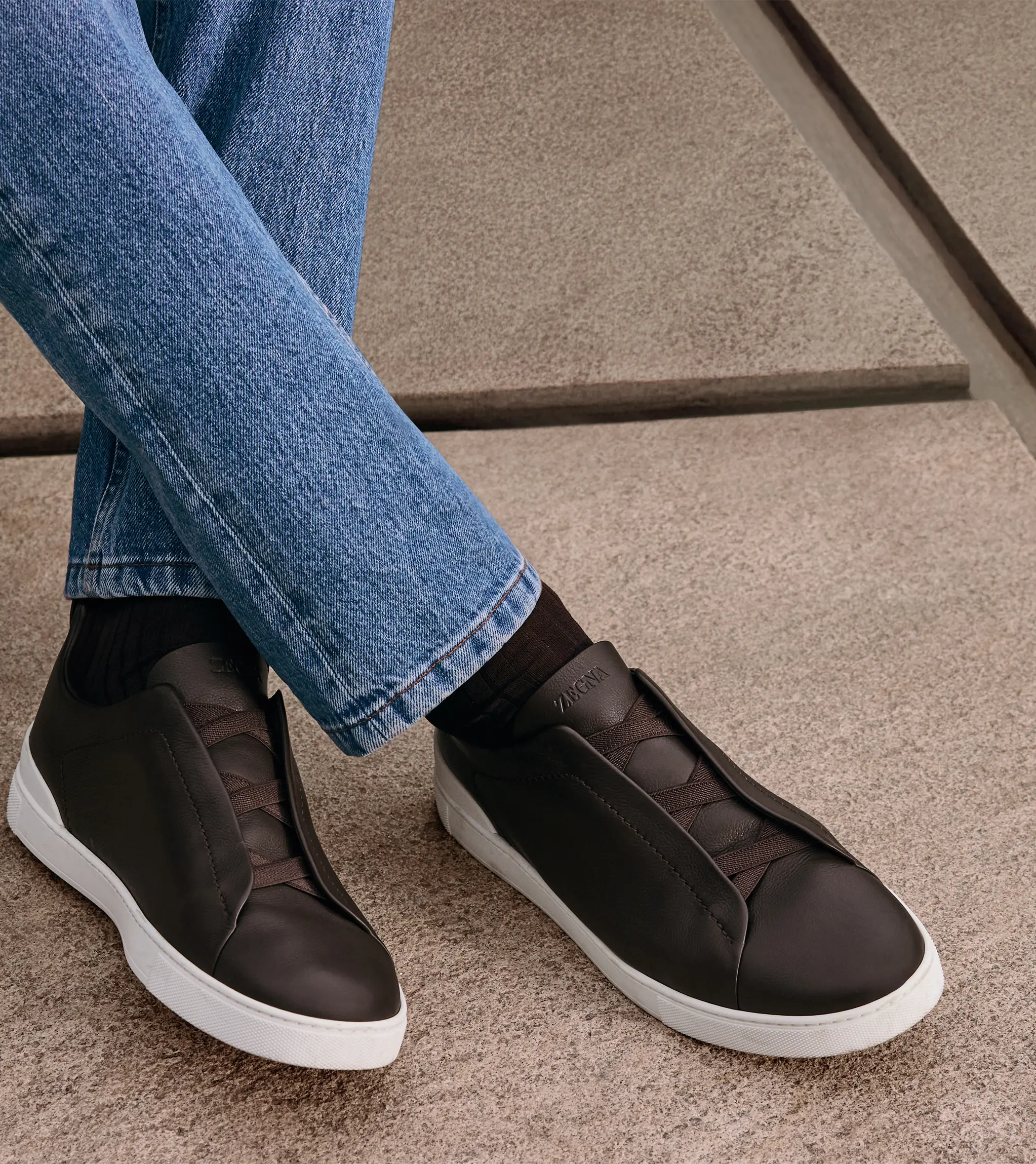 Man wearing luxury Triple Stitch™ sneakers with denim, from the ZEGNA Fall/Winter 2025 collection.