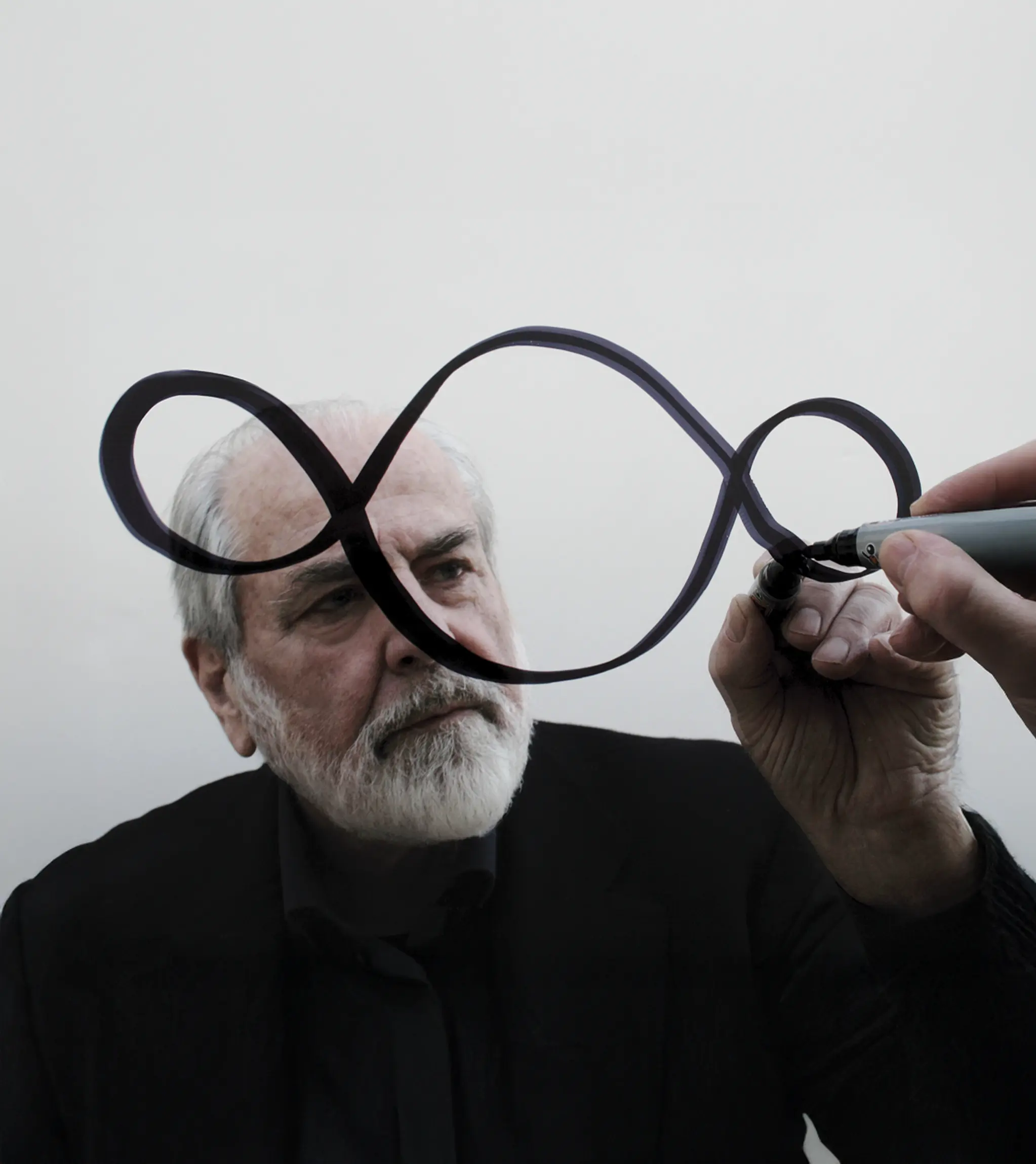 Michelangelo Pistoletto drawing the Third Paradise symbol on glass.