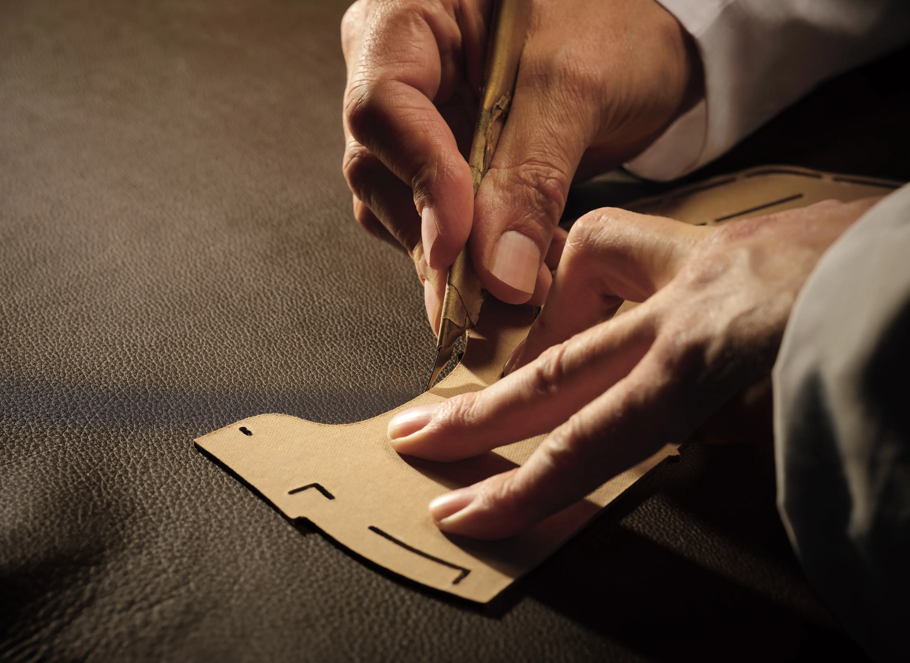 Image of a ZEGNA laboratory where SECONDSKIN leather is produced. A measuring tape is being used to measure a piece of leather.