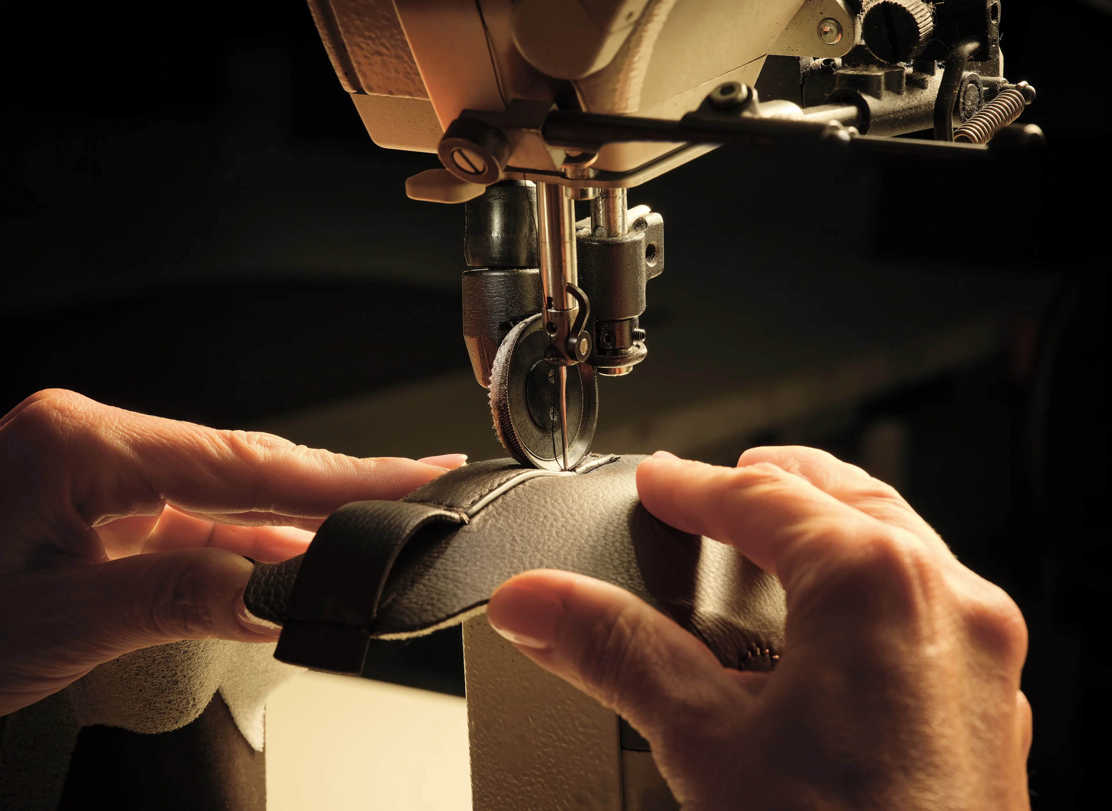 Image of a ZEGNA artisan sewing together pieces of leather to create Triple Stitch™ SECONDSKIN sneakers.