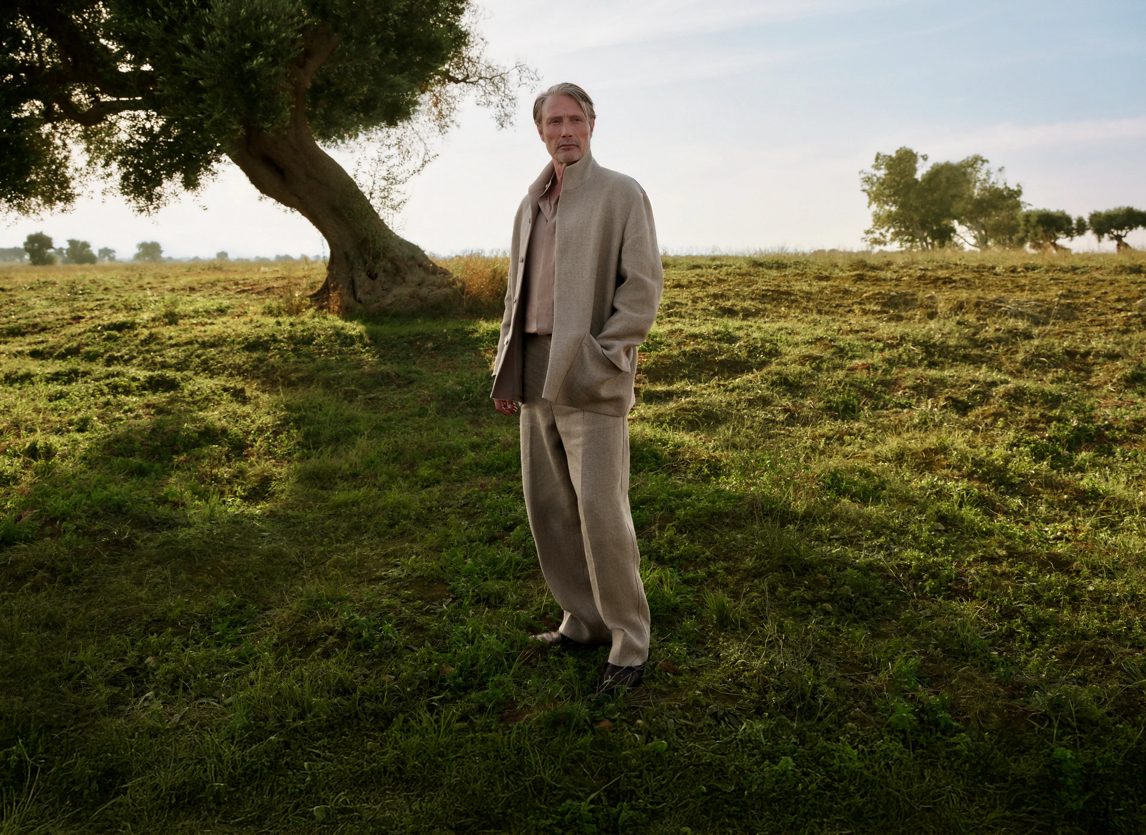 ZEGNA SS25コレクションのレザーのローファーと洗練されたリネンのアウトフィットを身に着けたMads Mikkelsen。