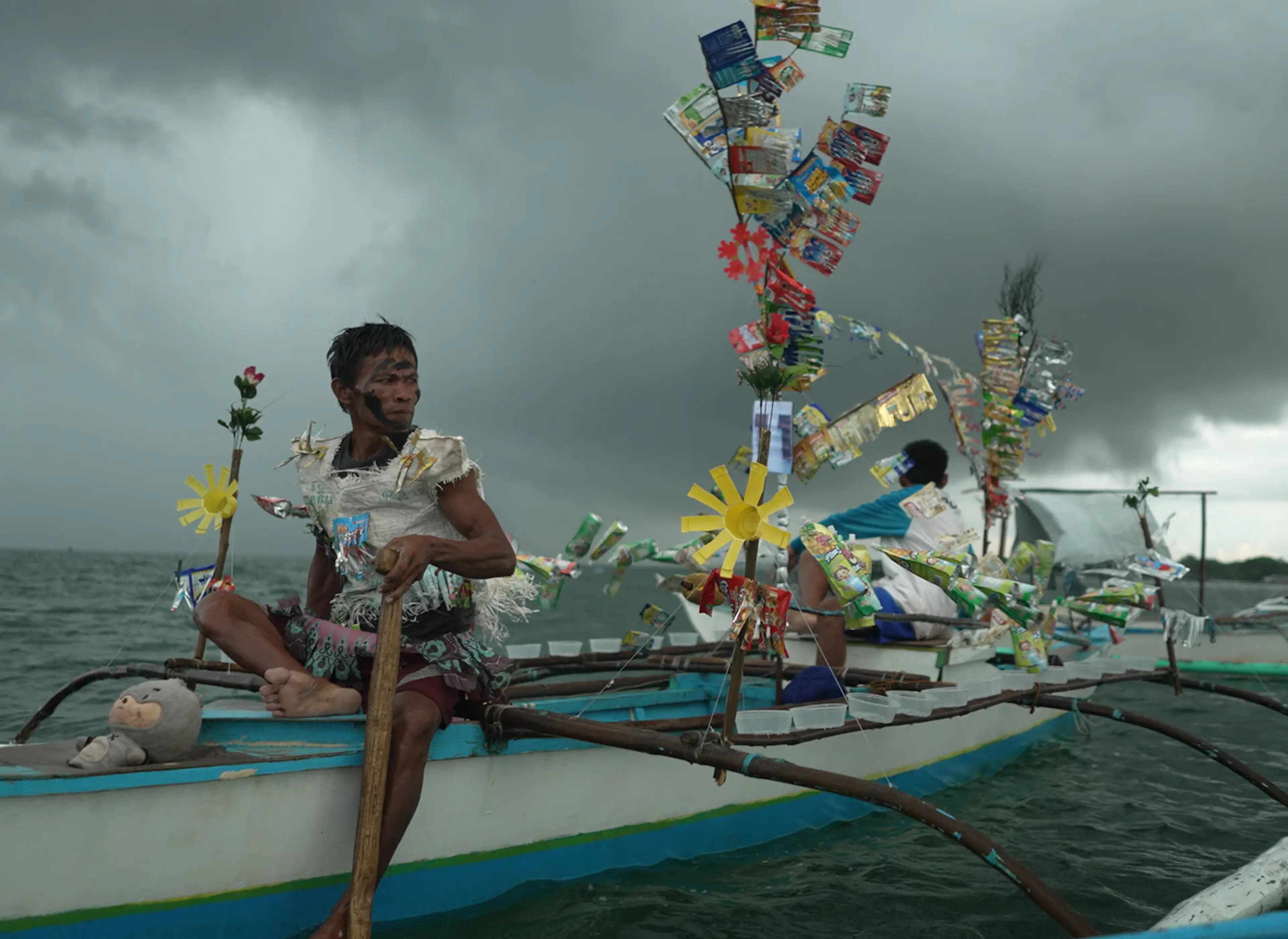 Fisherfolk, an artwork featuring a traditional fishing boat decorated with plastic waste to highlight ocean pollution.