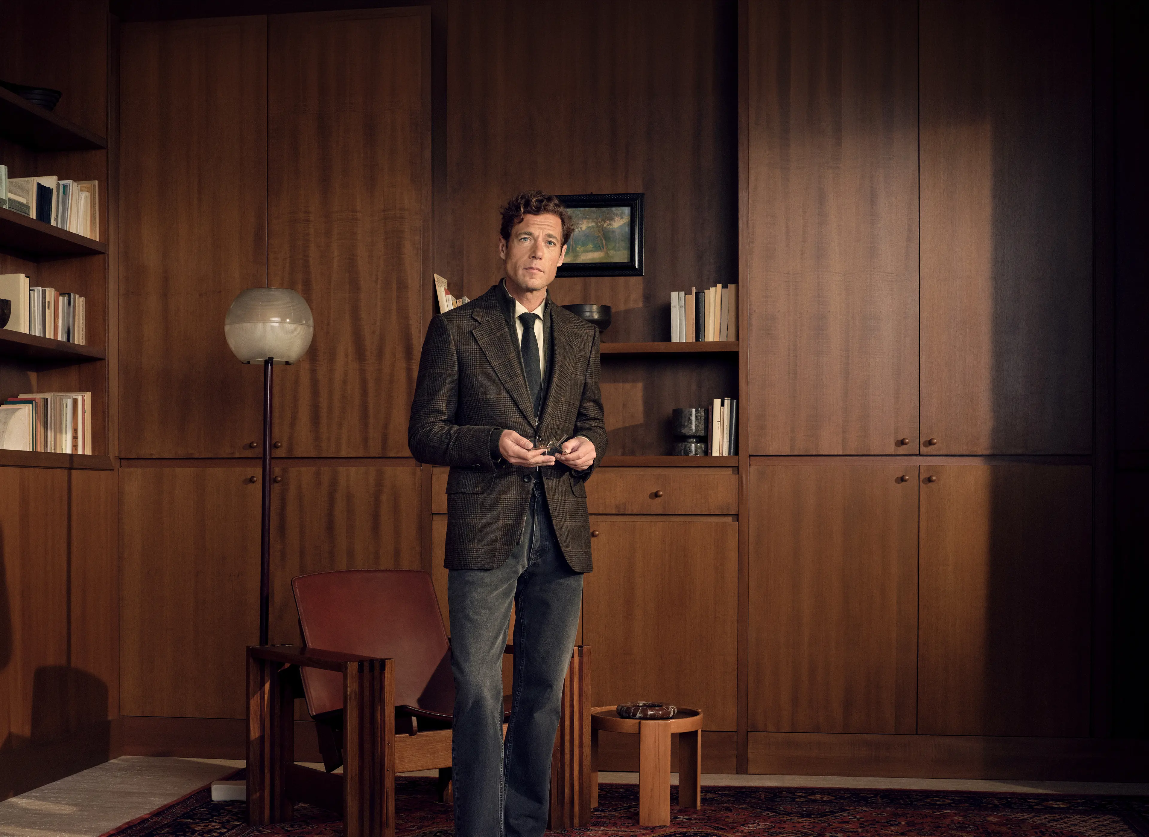 Man in a refined look wearing the Oasi Cashmere Jacket in dark olive green and black Prince of Wales with a wool jacquard tie and pure cotton Roccia denim in dark grey, from the ZEGNA Fall/Winter 2026 collection.