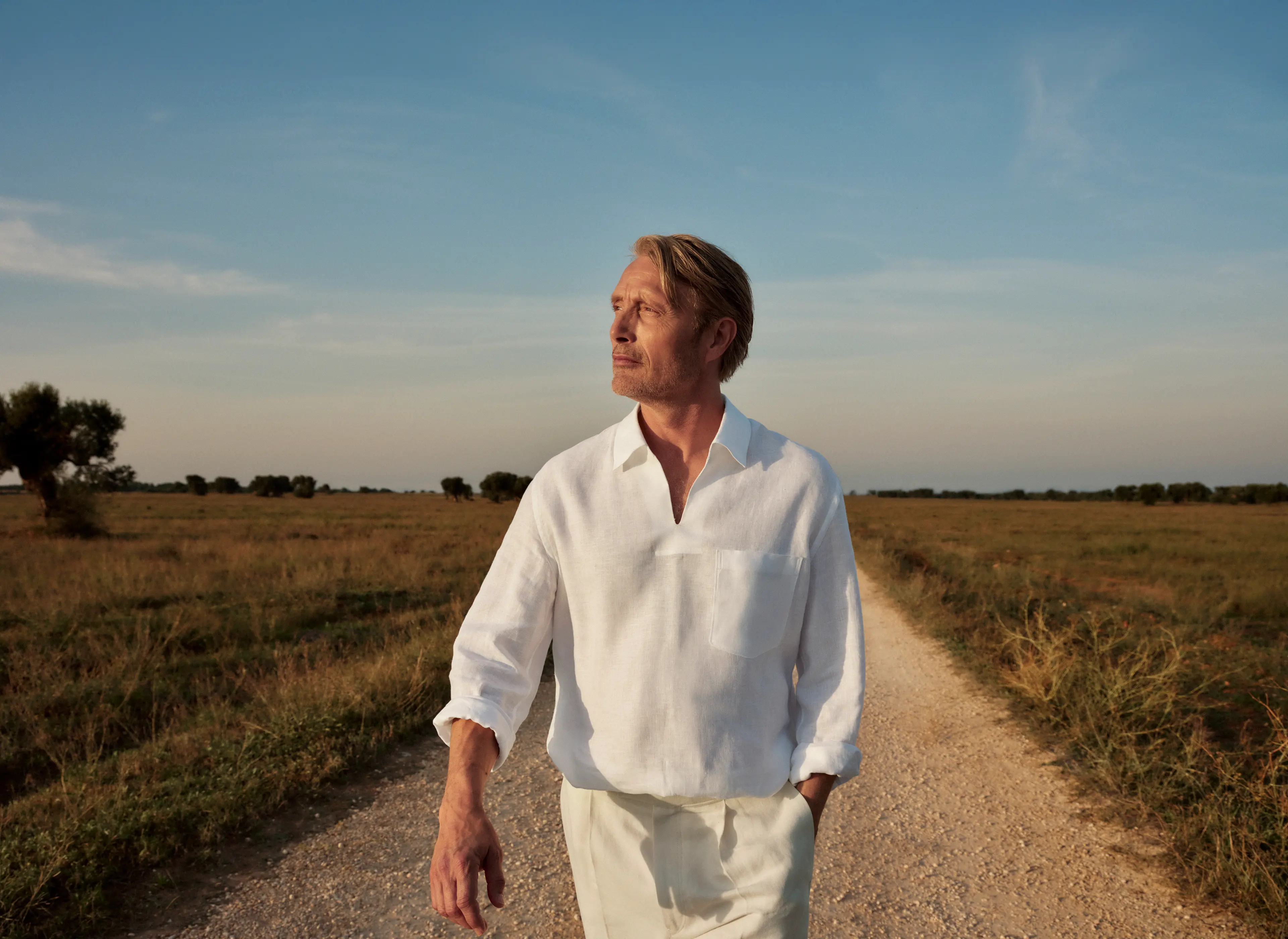 Mads Mikkelsen trägt ein edles Leinen-Outfit, kombiniert mit Wildleder-Loafern aus der ZEGNA SS25 Kollektion.