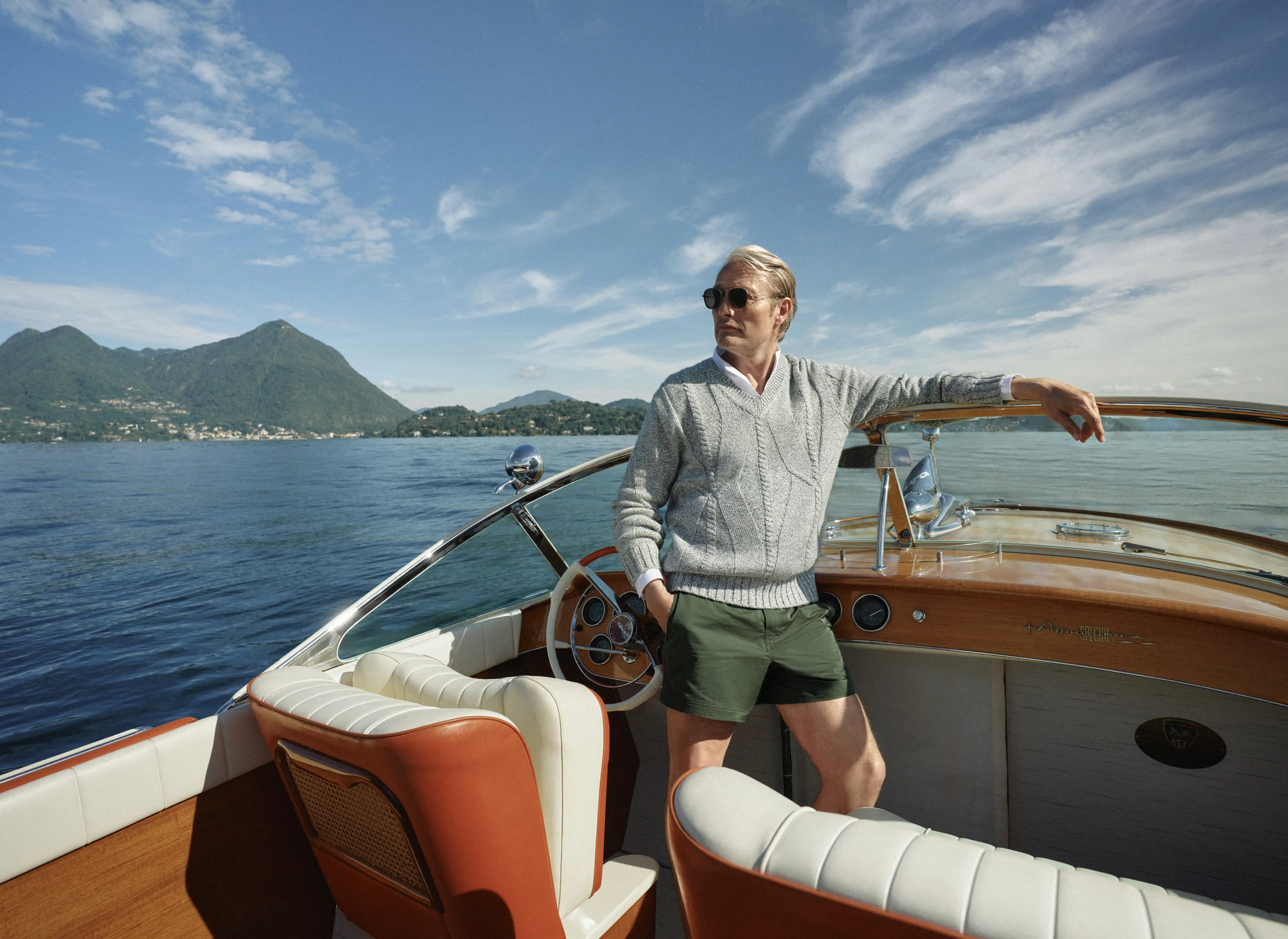 Mads Mikkelsen on a boat wearing a ZEGNA Spring Summer 2026 look featuring a V-neck sweater and the iconic Rio beachwear