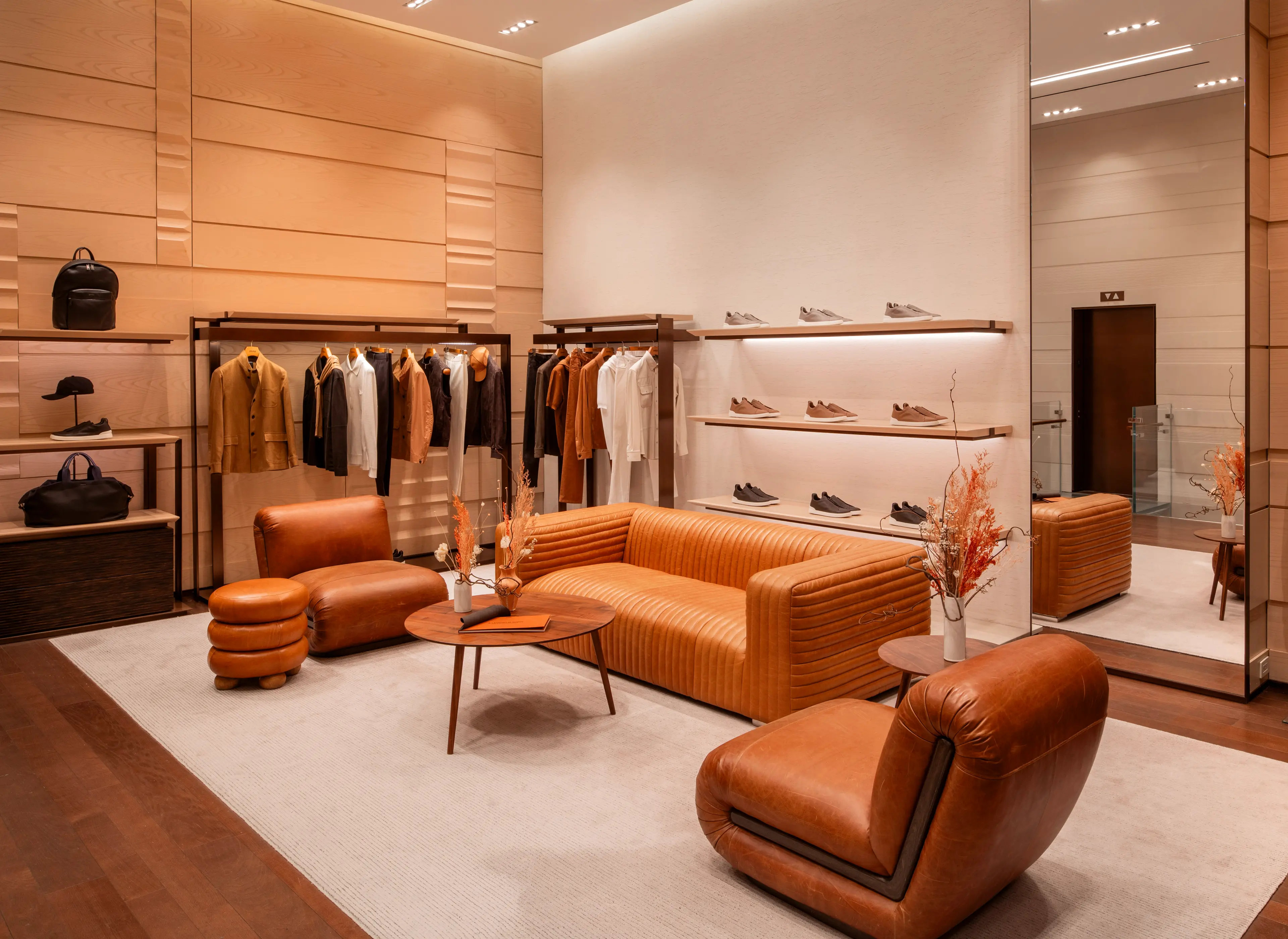 Interior of ZEGNA luxury boutique with shoes, bags, and clothing elegantly displayed on shelves.