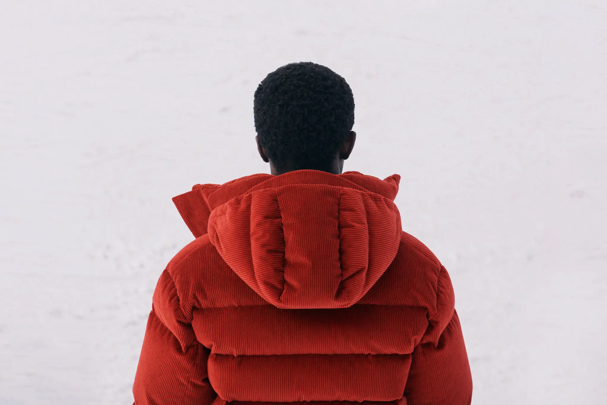 Un homme portant le blouson matelassé en duvet Cashco Elements rouge foncé de ZEGNA.