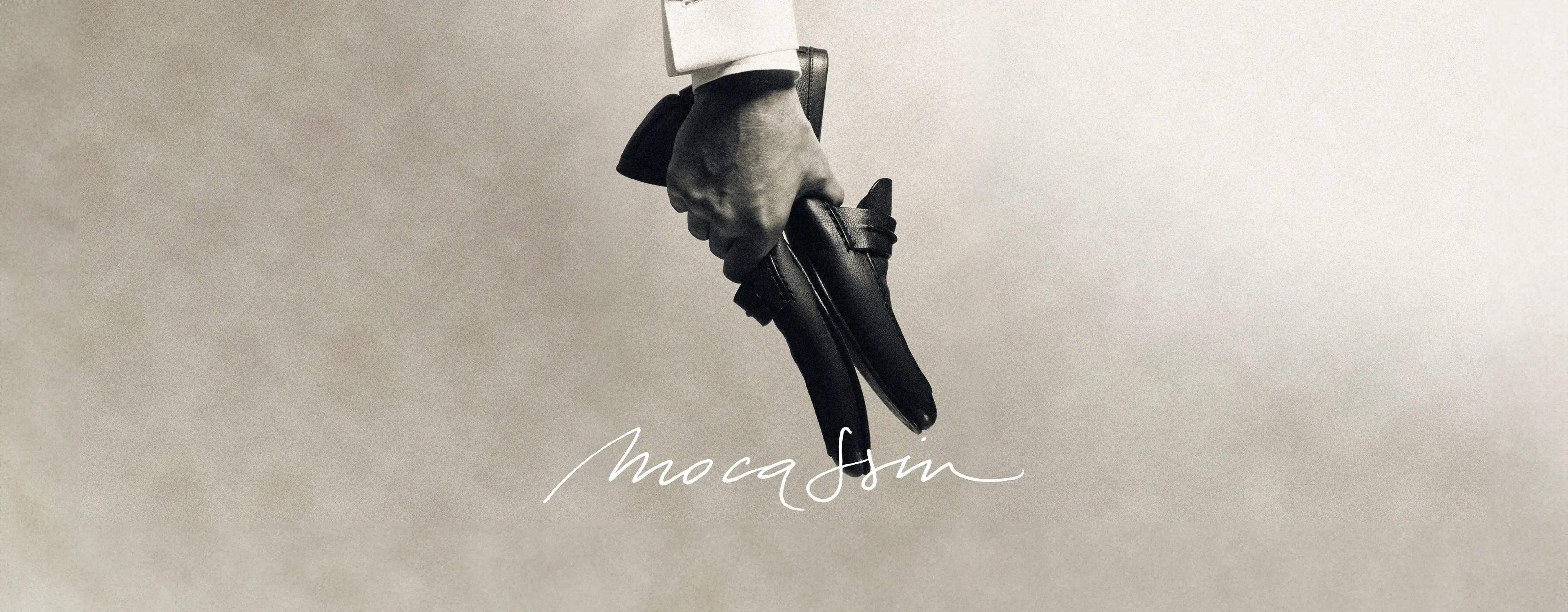 Hand holding a pair of ZEGNA Mocassin loafers, showcasing their elegant craftsmanship.
