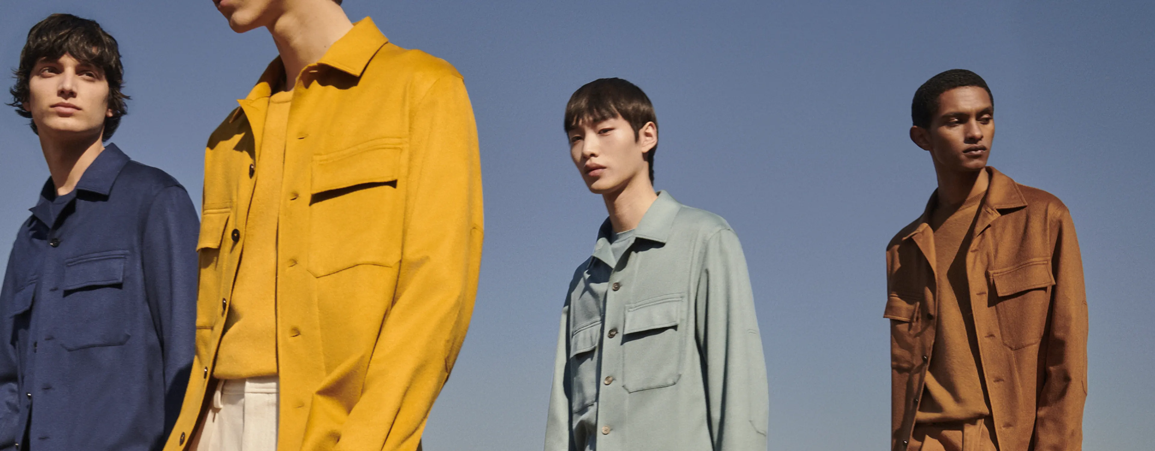 四位身着不同颜色 Zegna Oasi Cashmere 2022 年秋冬系列外套衬衫的男士