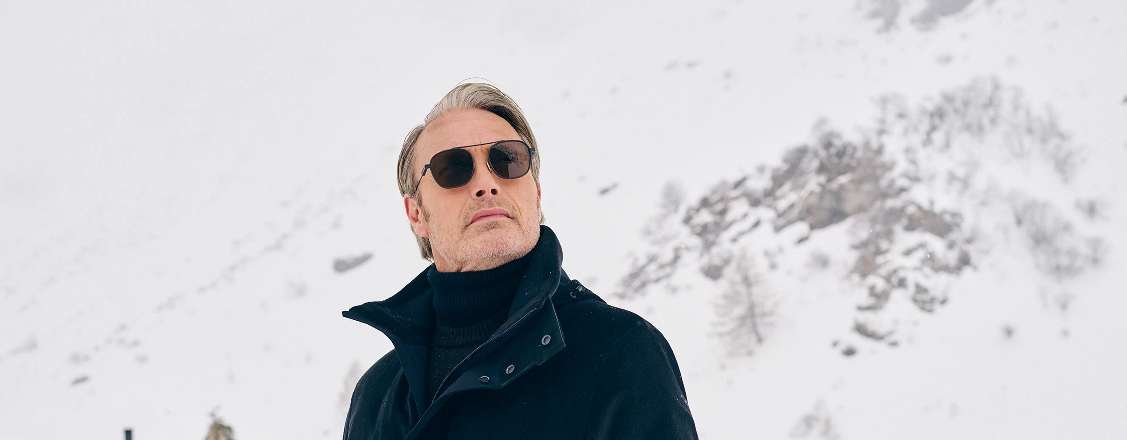 Mads Mikkelsen wearing a ZEGNA winter look featuring a ski suit.