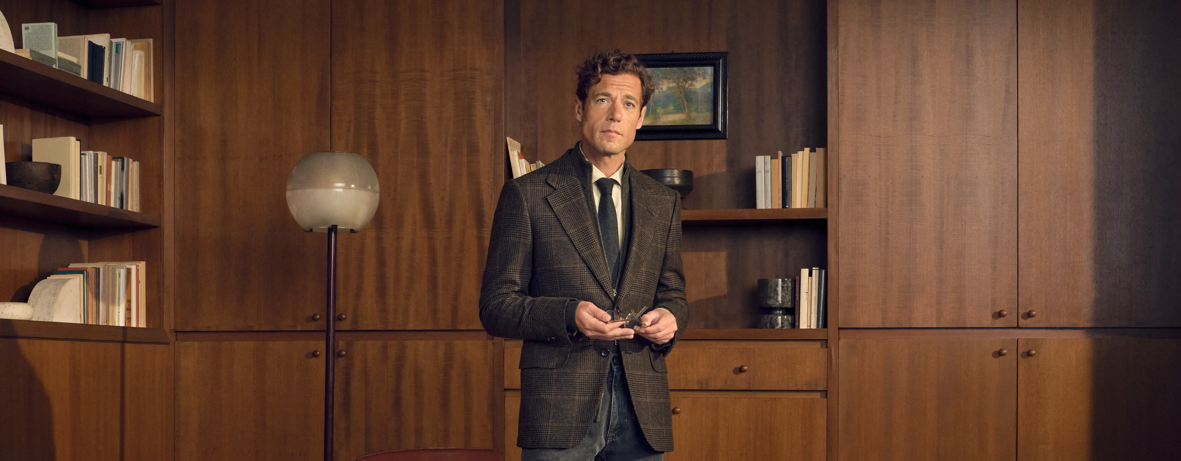 Man in a refined look wearing the Oasi Cashmere Jacket in dark olive green and black Prince of Wales with a wool jacquard tie and pure cotton Roccia denim in dark grey, from the ZEGNA Fall/Winter 2026 collection.